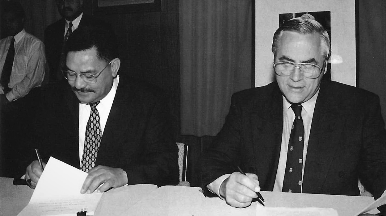 Sir Robert Mahatu and others signing documents.